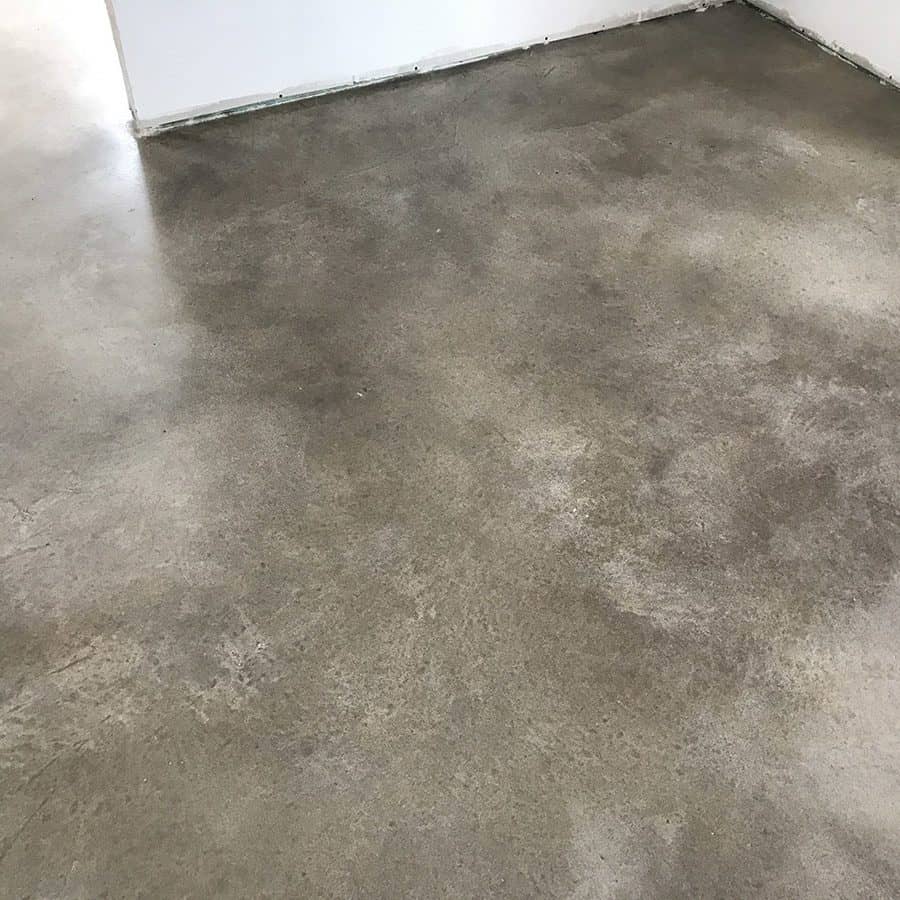 Grey stained concrete epoxy installed on a square floor